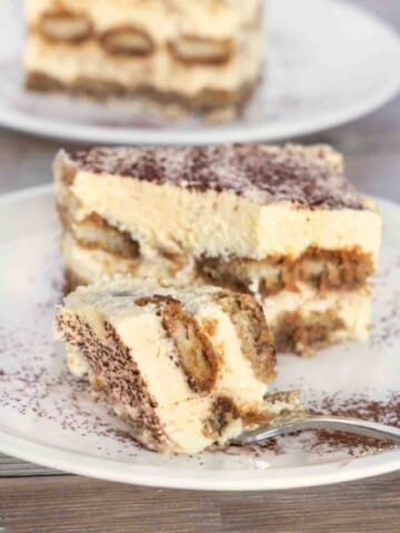 Tiramisu with a fork on a white plate