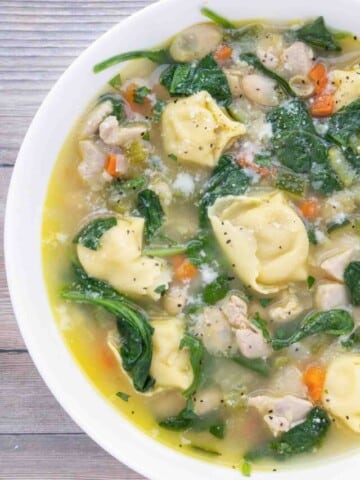 chicken tortellini soup in a white bowl.