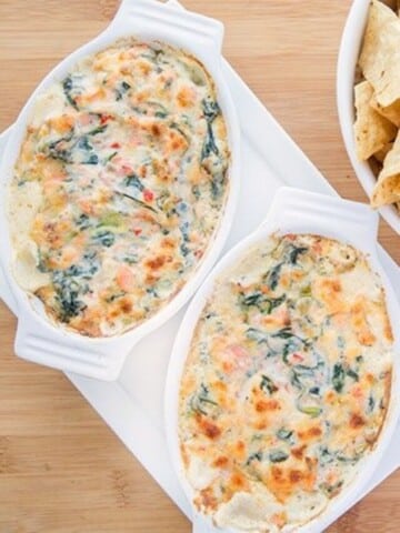 white oval baking dish filled with salmon and spinach dip
