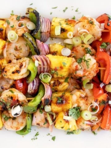 Grilled Shrimp and pineapple skewers on a white platter