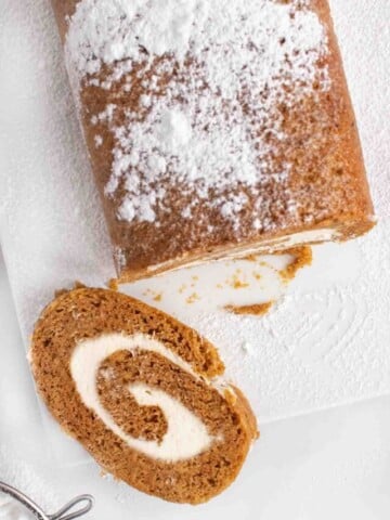 slice of pumpkin roll with the rest of the roll