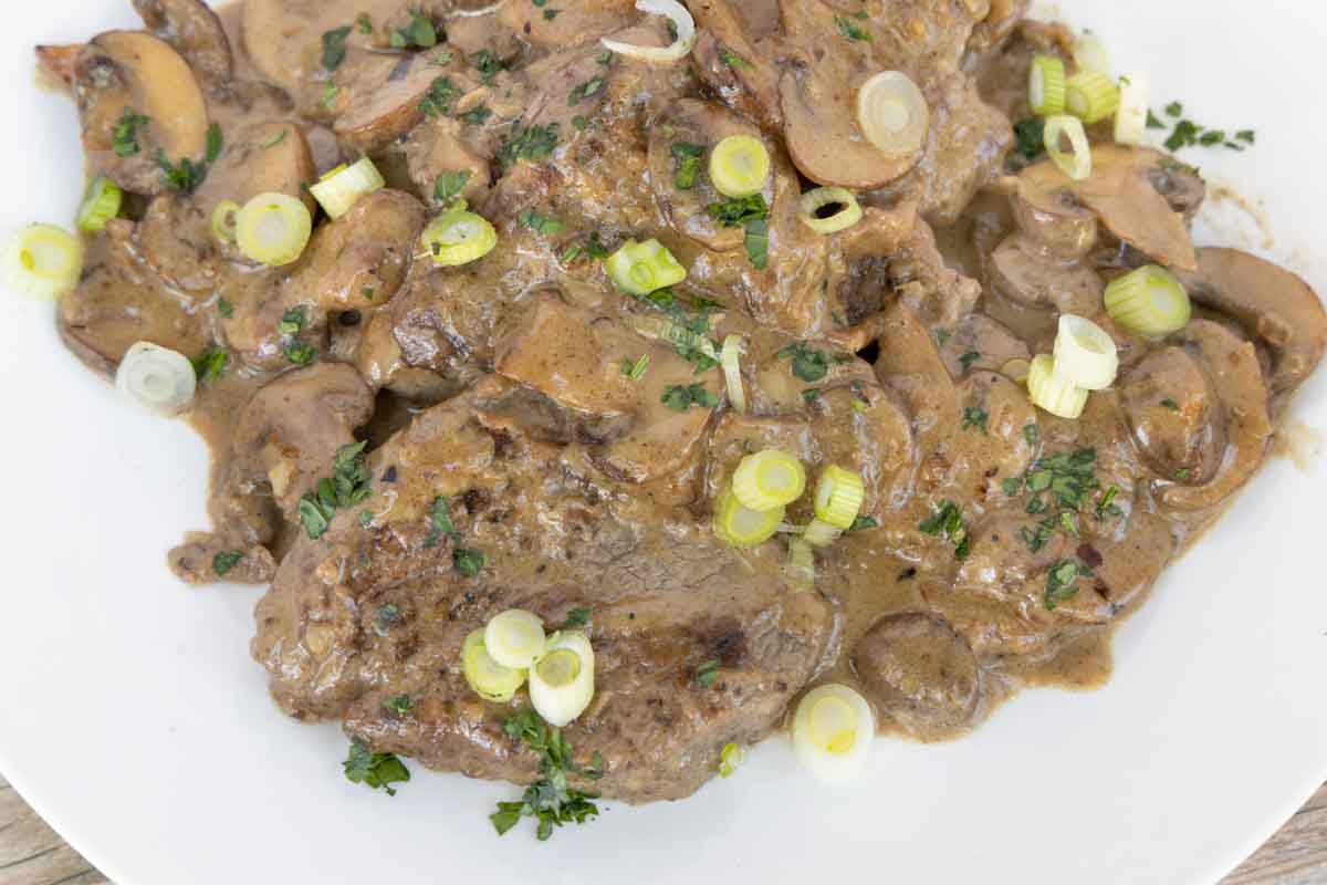 Steak Diane on a white plate.