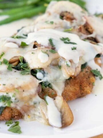 chicken florentine with supreme sauce on a white plate