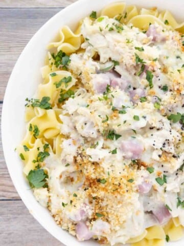 chicken cordon bleu casserole over egg noodles in a white bowl