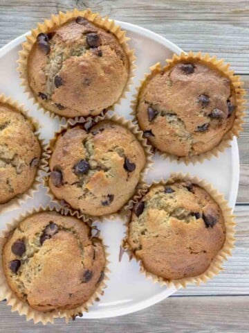 banana chocolate chip muffins on a white plate.