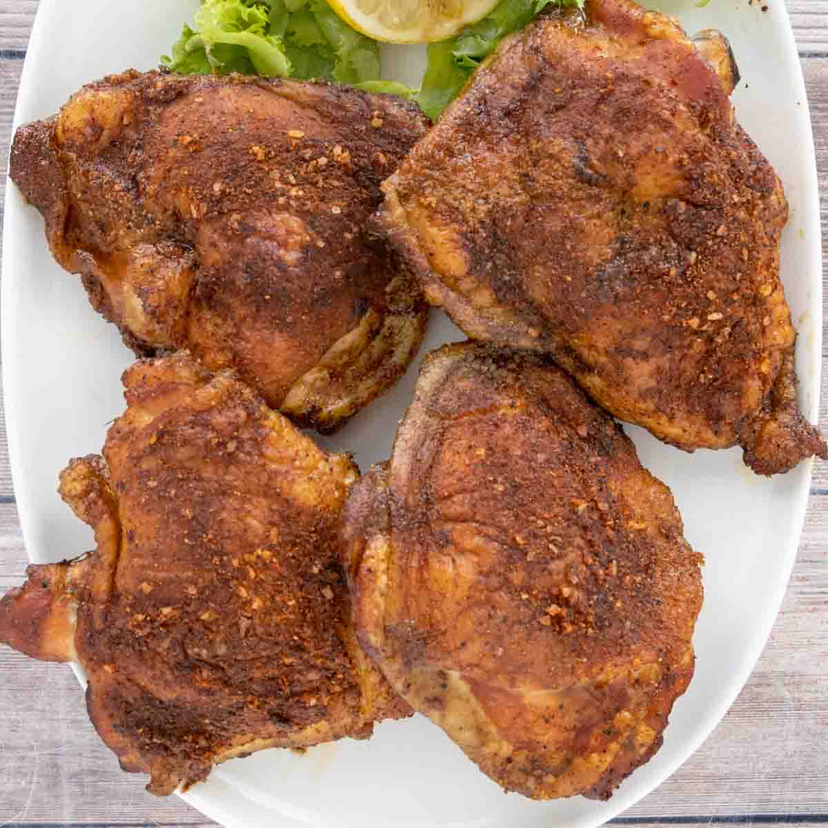Smoked Chicken Thighs on a white platter.
