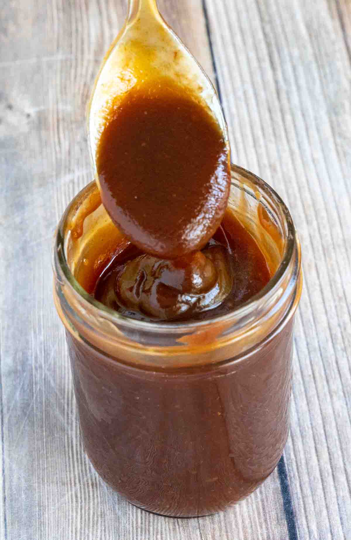 Tonkatsu sauce in a glass jar with a spoon coming out.