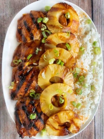 Huli Huli chicken with pineapple and rice on white platter.