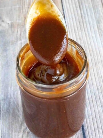 Tonkatsu sauce in a glass jar with a spoon coming out.