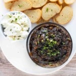 Caramelized onion jam on a white platter with toasts and goat cheese.