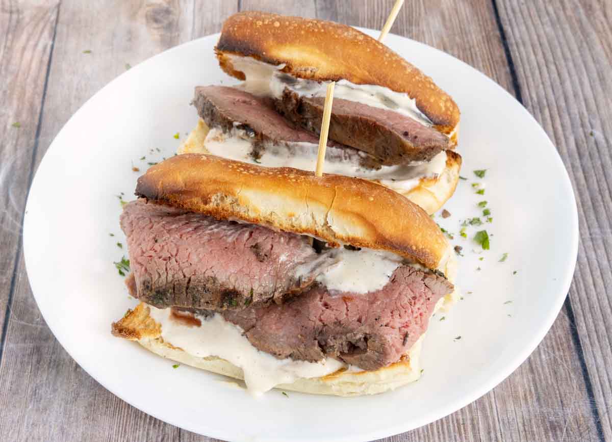Smoked tri-tip steak sandwiches on a white plate.