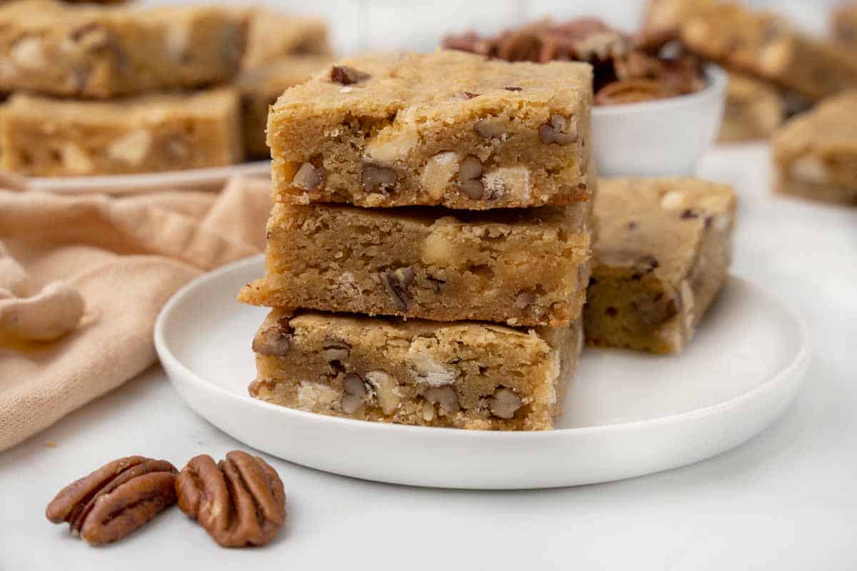 Blondies stacked on a white platter.