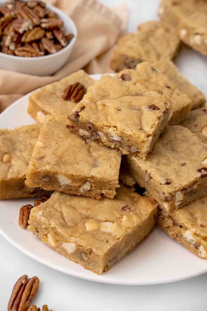 Blondies stacked on a white platter.