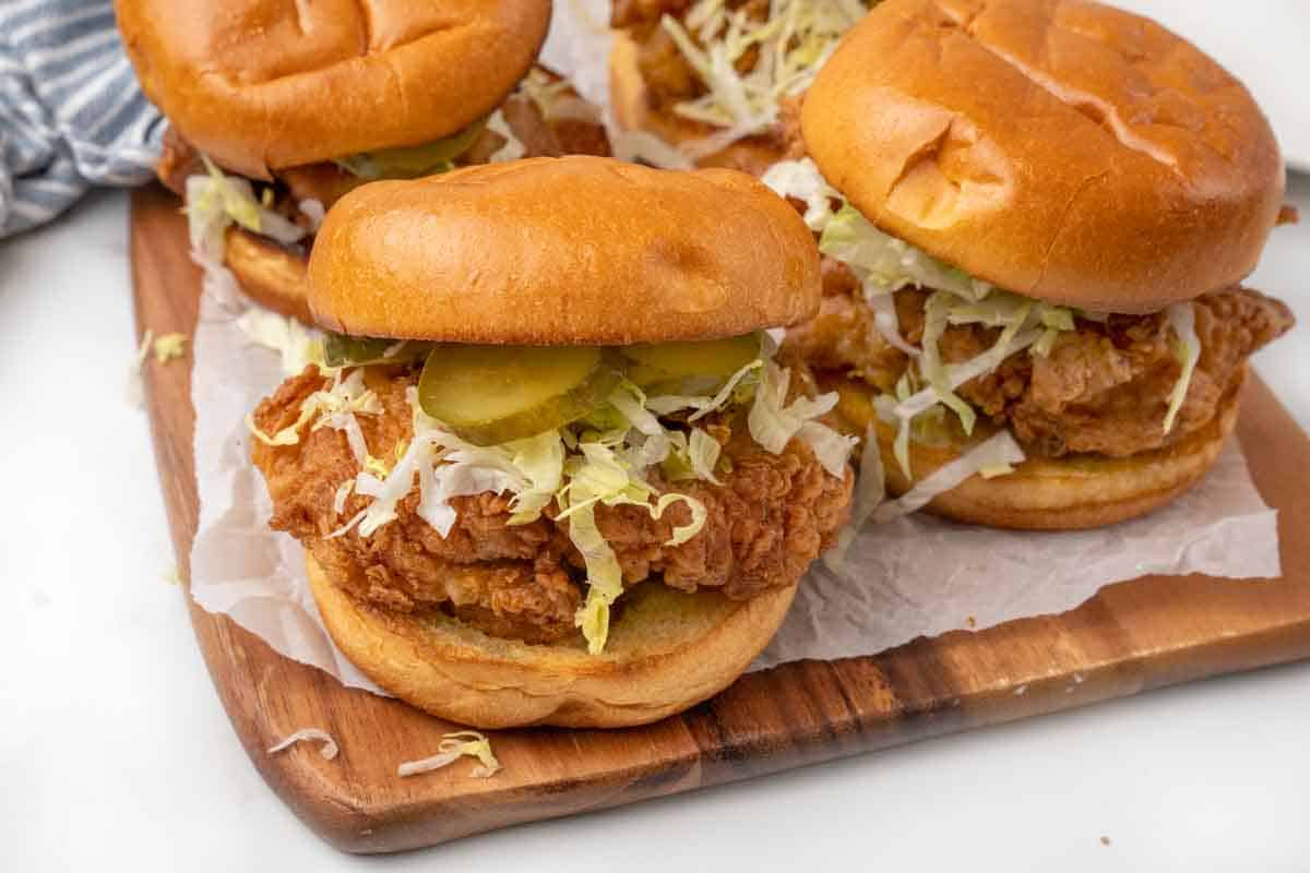 Fried chicken sandwiches on a cutting board.