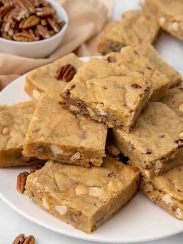 Blondies stacked on a white platter.