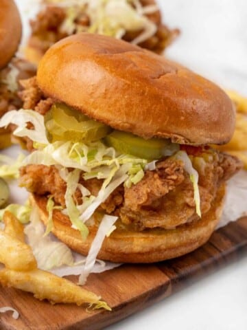 Fried chicken sandwich on a cutting board.