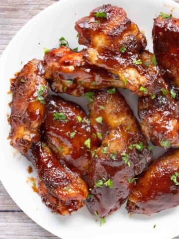 honey barbecue chicken wings on a white plate.