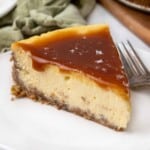 caramel cheesecake on a white plate with a fork.