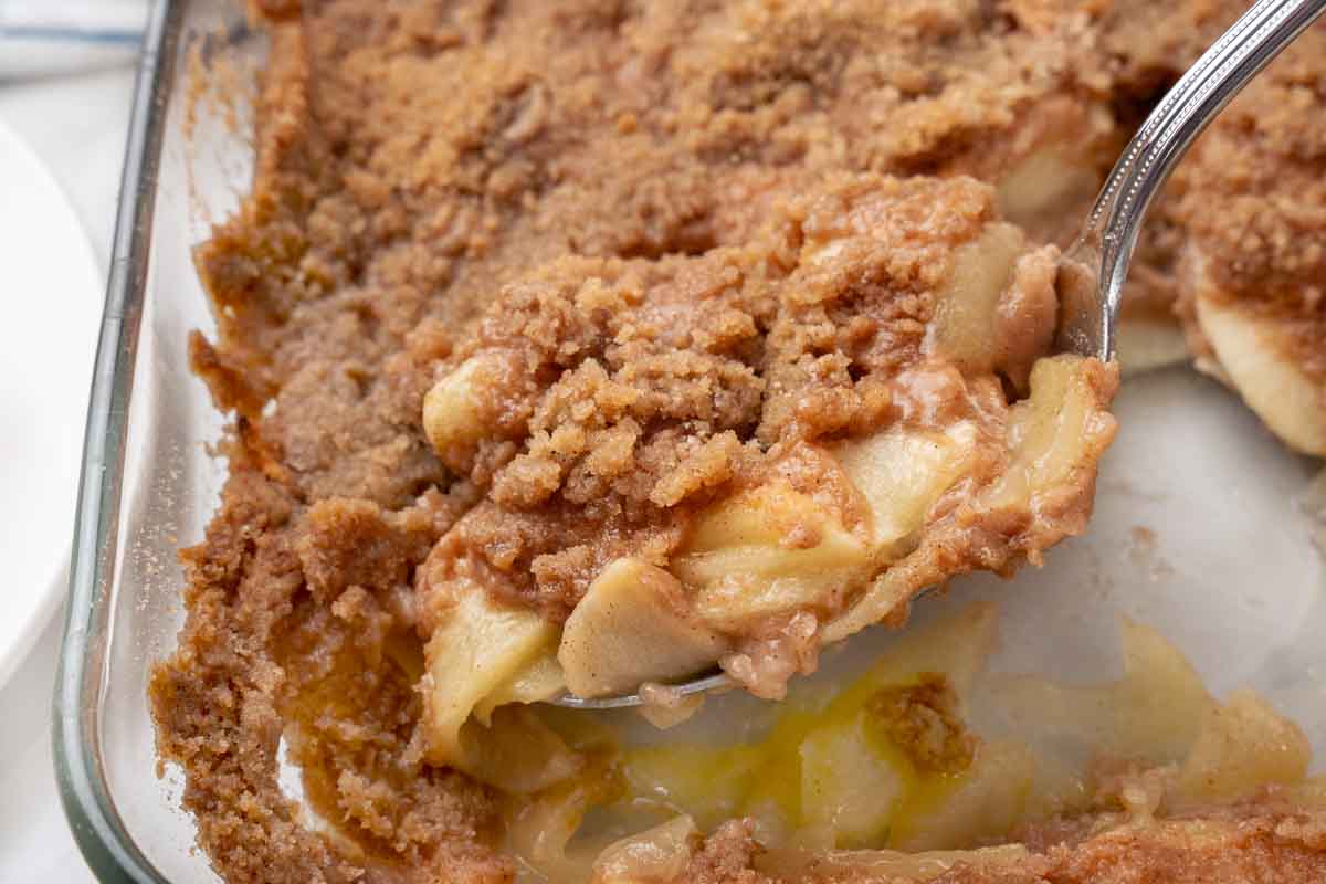 Apple Brown Betty in a baking pan with spoon.