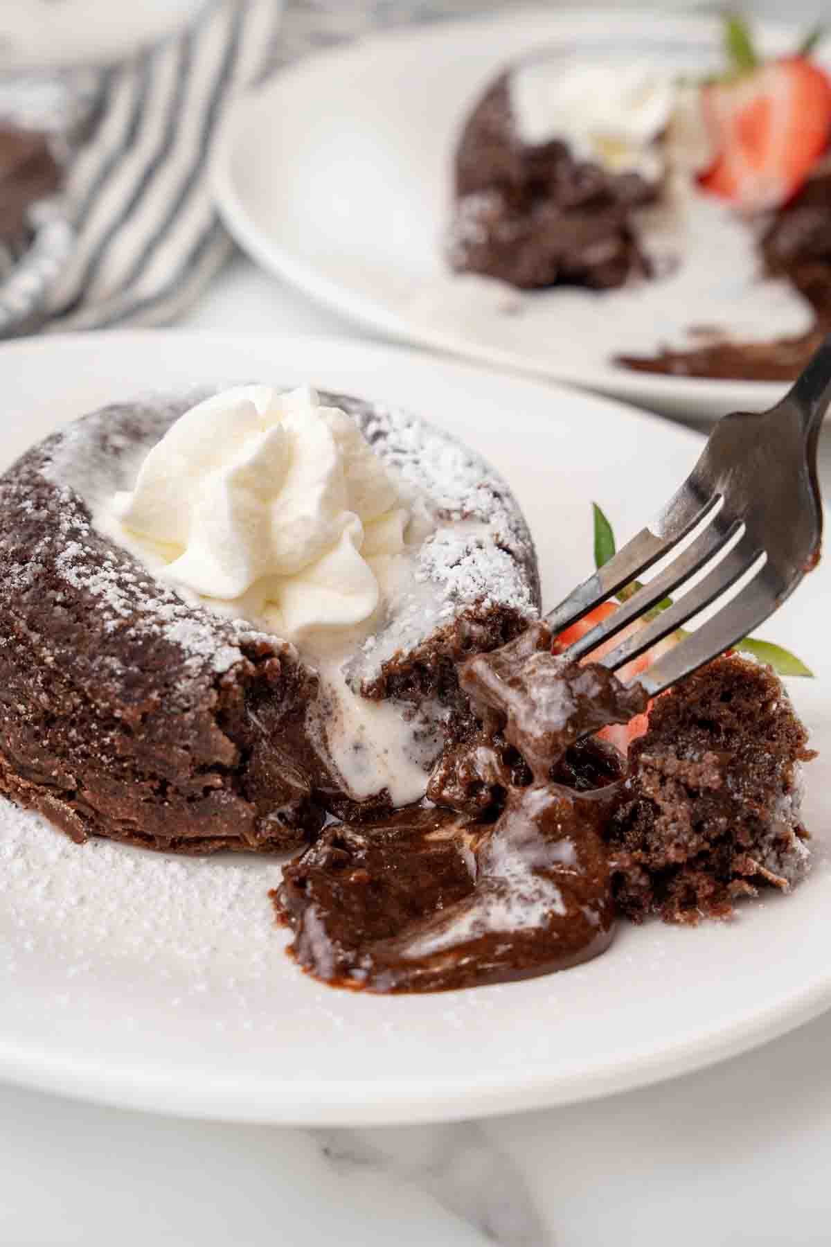 Lava cake with a fork in it with the chocolate oozing onto the plate.