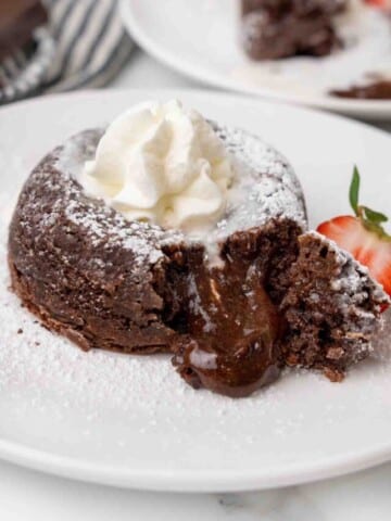 Lava cake cut open with the chocolate oozing onto the plate.