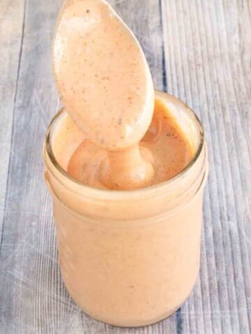 Burger sauce in a glass jar with a spoon coming out.