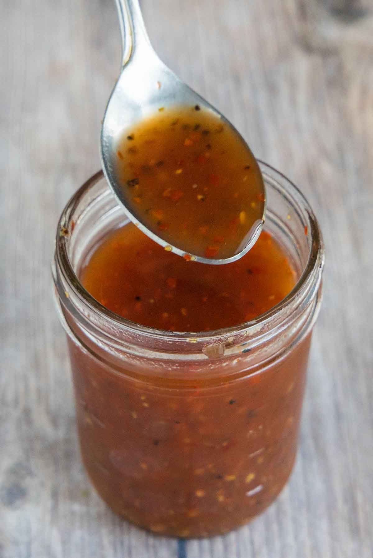 Jar of Carolina vinegar BBQ sauce with spoon coming out of the jar.