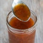 Jar of Carolina vinegar BBQ sauce with spoon coming out of the jar.