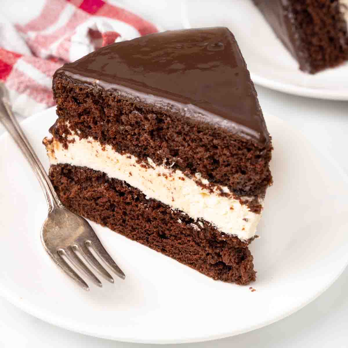 Slice of ding dong cake on a white plate with a fork.