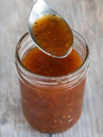 Jar of Carolina vinegar BBQ sauce with spoon coming out of the jar.