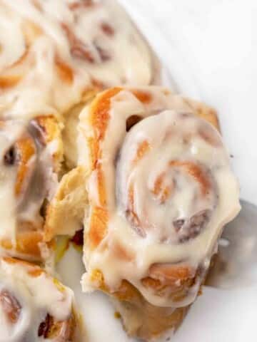 easy cinnamon roll being taken off the plate.