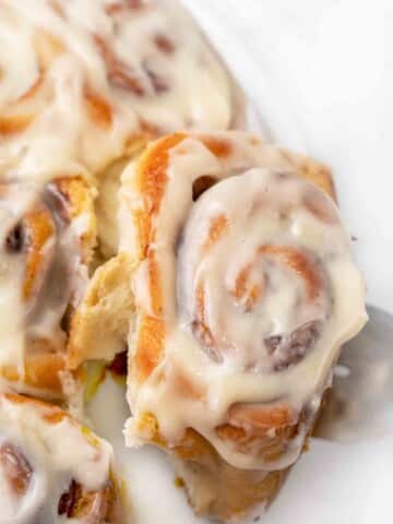 easy cinnamon roll being taken off the plate.