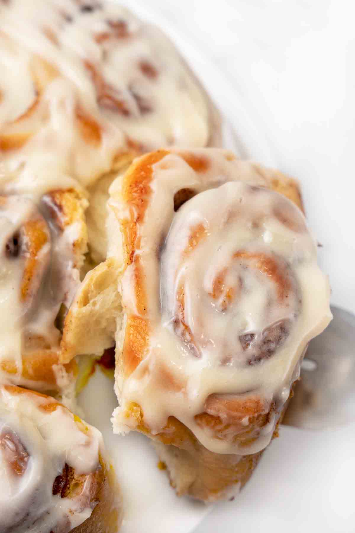 easy cinnamon roll being taken off the plate.