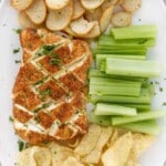 Smoked cream cheese with chips, toasts and celery on a white platter.