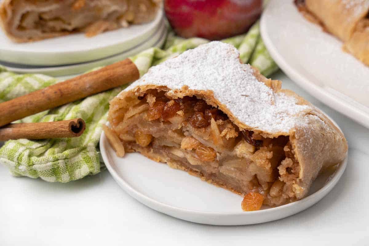 Slice of apple strudel on a white plate.