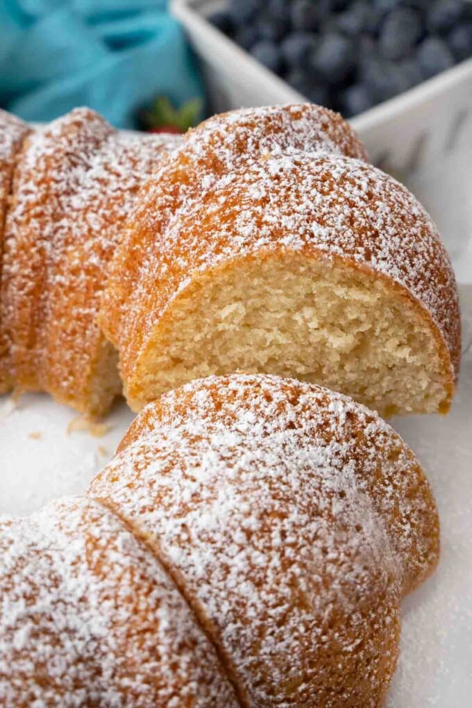 Slice of Vanilla Bundt Cake being taken out of the whole cake.