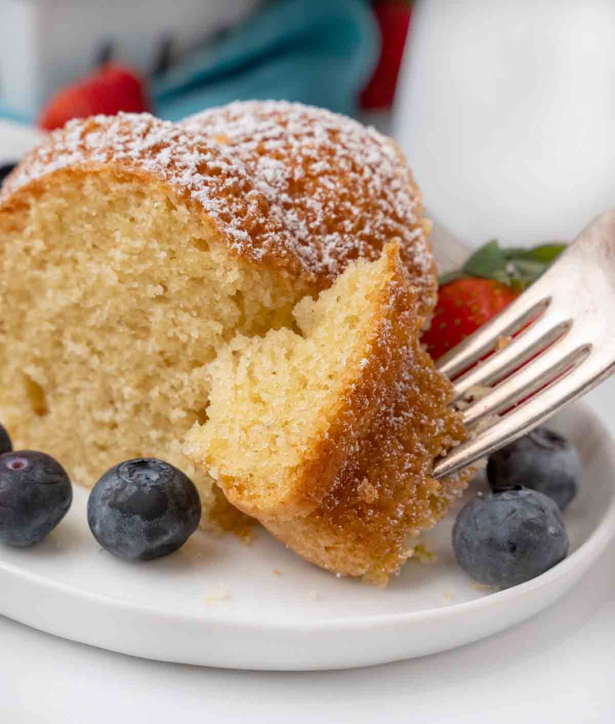 Slice of Vanilla Bundt Cake with a fork in a piece on a white plate..