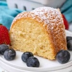 Slice of Vanilla Bundt Cake on a white plate with blueberries.