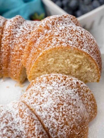 Slice of Vanilla Bundt Cake being taken out of the whole cake.