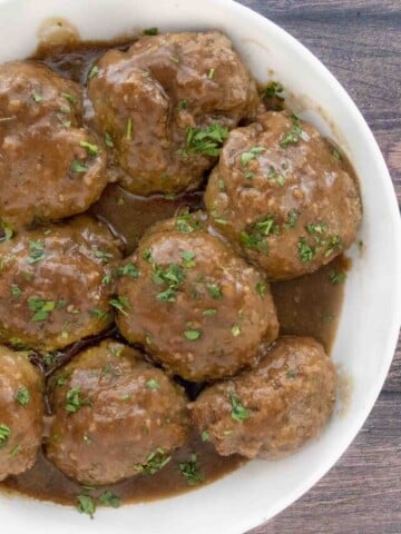 Smoked meatballs and gravy in a white bowl.