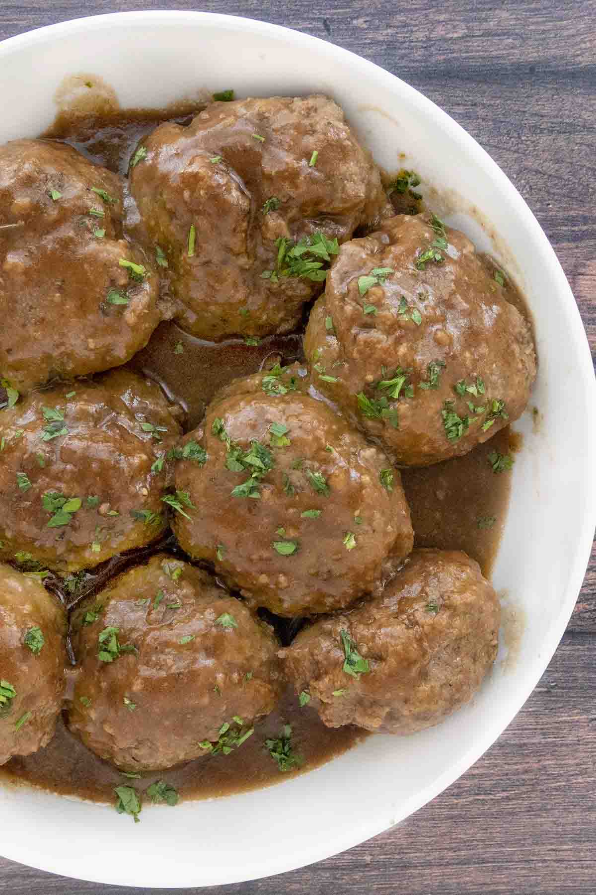 Smoked meatballs and gravy in a white bowl.