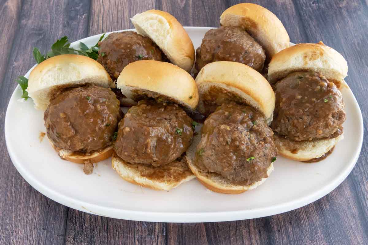 Smoked meatball sliders on a white platter.