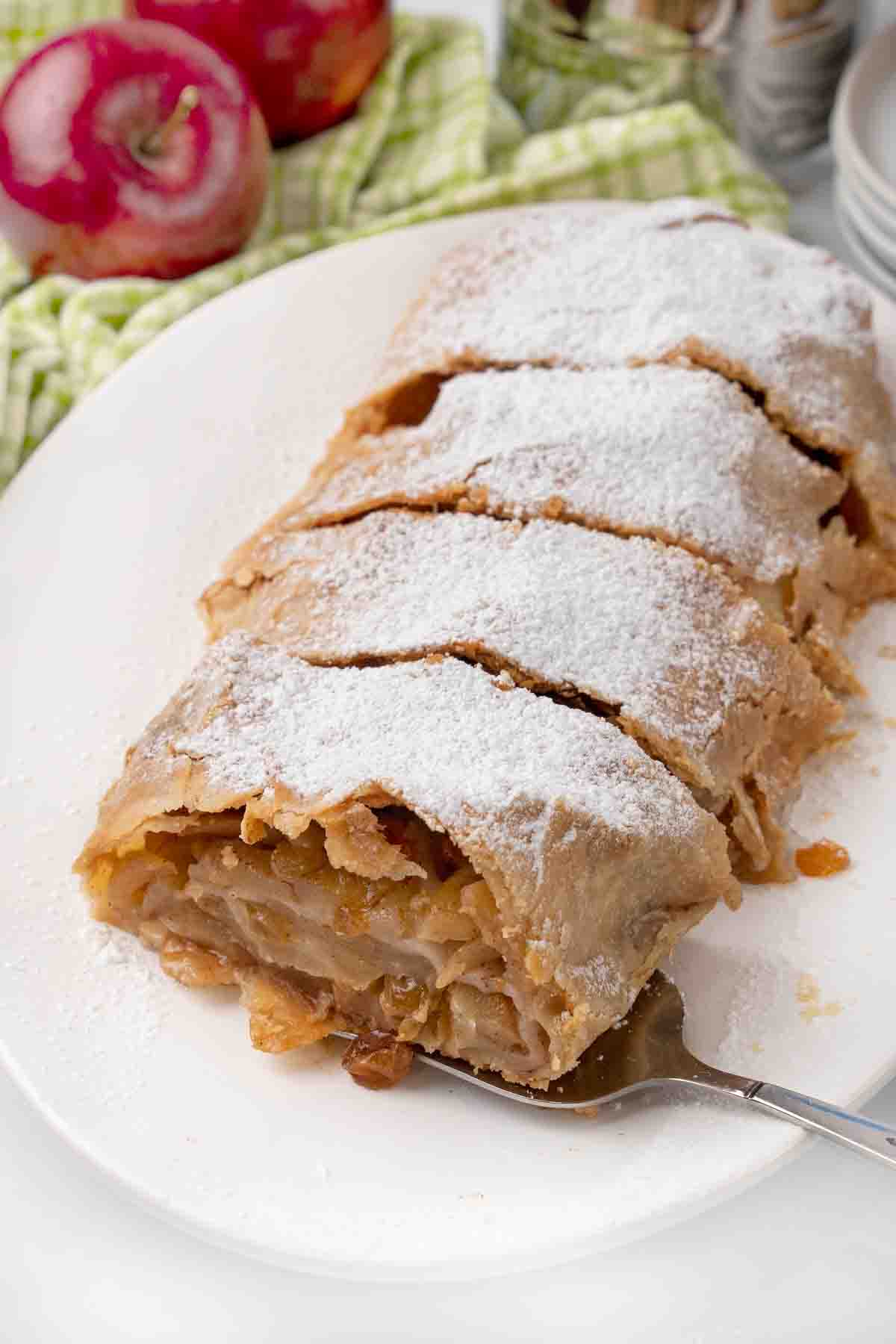 sliced apple strudel on a white platter.