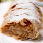 sliced apple strudel on a white platter.