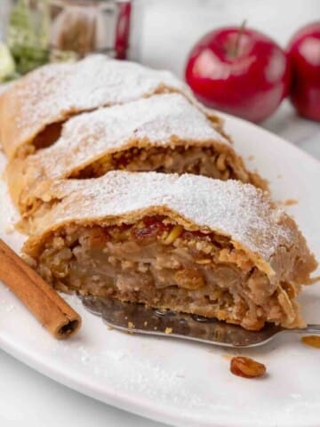 sliced apple strudel on a white platter.