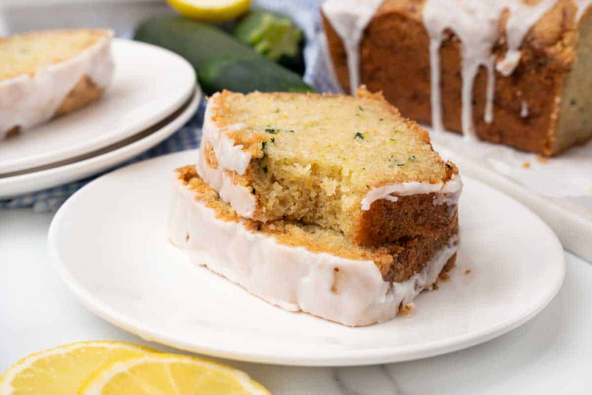 Two slices of lemon zucchini bread on a white plate.