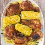 Per-peri chicken on a white platter with corn on the cob.