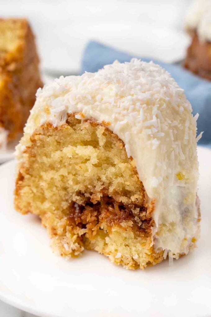 Slice of Tom Cruise Coconut Cake on a white plate.