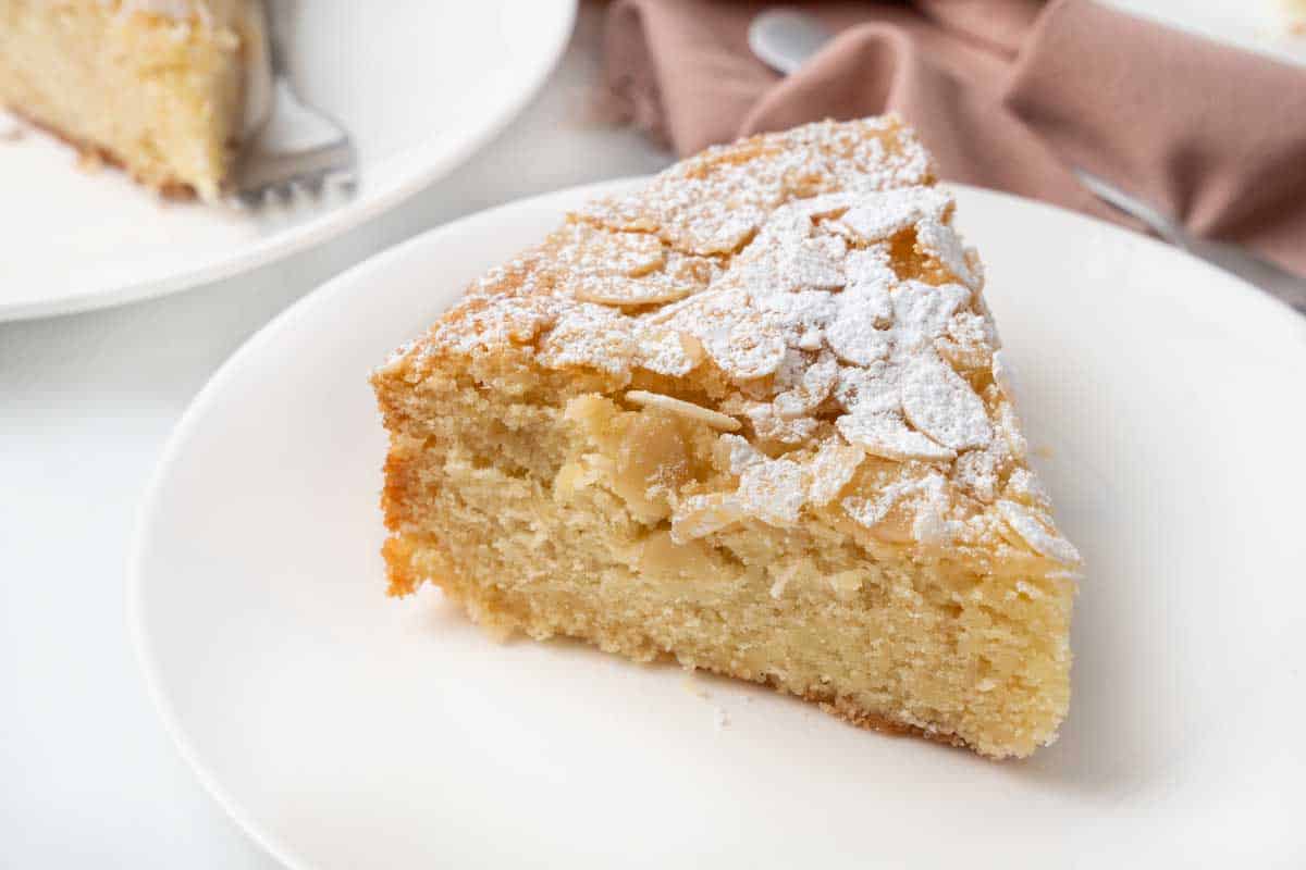 Slice of almond cake on a white plate.