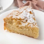 Slice of almond cake on a white plate.